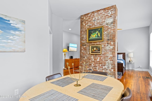 dining space with wood-type flooring and baseboards