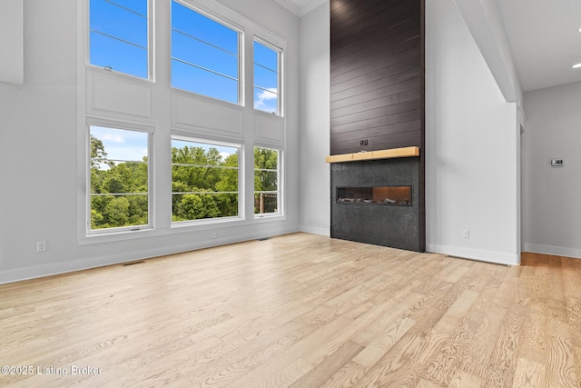 118 Stable Way, Jeffersonville, IN 47130 - unfurnished living room featuring a fireplace, wood finished floors, baseboards, and a high ceiling