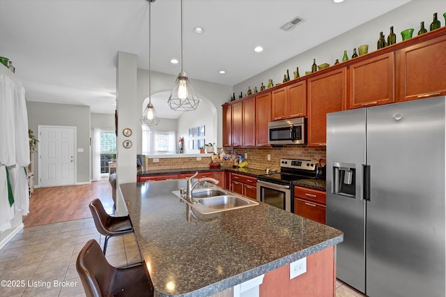 11601 Top Walnut Loop, Louisville, KY 40229 - kitchen with stainless steel appliances, a sink, dark countertops, tasteful backsplash, and pendant lighting