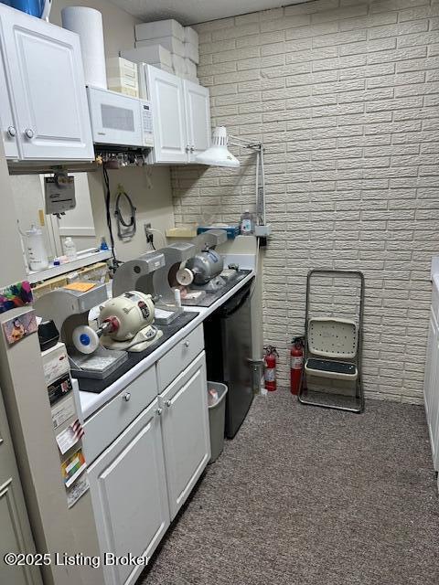 4012 Dupont Cir Unit 214, Louisville, KY 40207 - kitchen featuring white microwave, white cabinetry, light countertops, and carpet