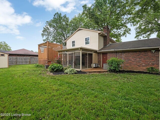 8703 Bards Ct, Louisville, KY 40299 - rear view of house featuring a sunroom, brick siding, and a chimney