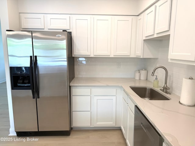 11302 Deering Rd, Louisville, KY 40272 - kitchen with appliances with stainless steel finishes, white cabinets, decorative backsplash, light stone counters, and light wood finished floors