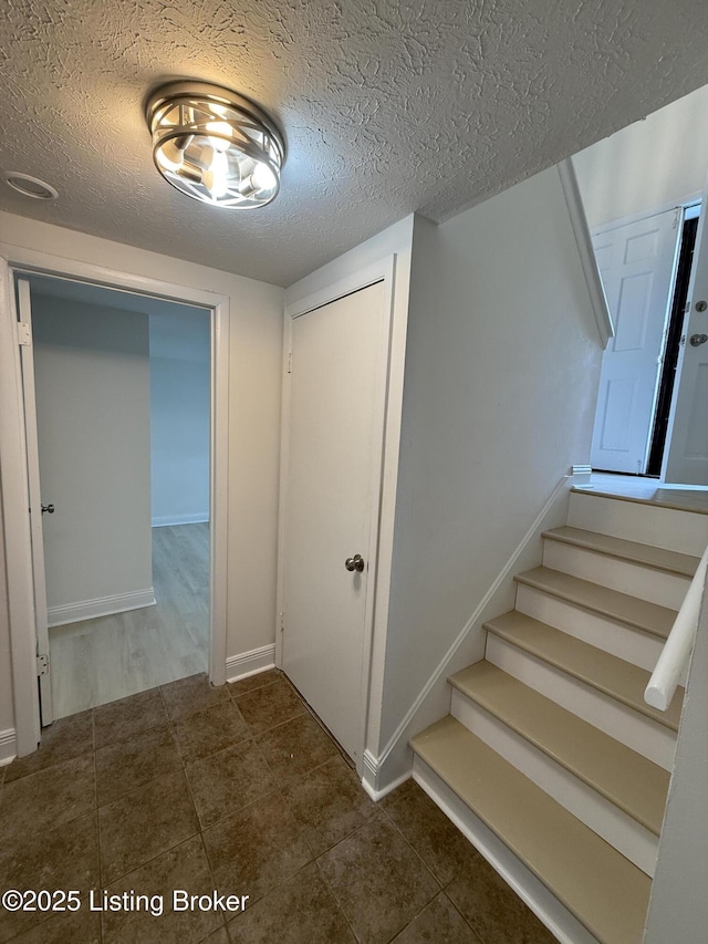 11302 Deering Rd, Louisville, KY 40272 - stairway featuring a textured ceiling and tile patterned floors
