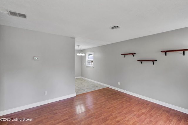 6106 Dobson Ct, Louisville, KY 40229 - spare room featuring a chandelier, light wood-style flooring, and baseboards