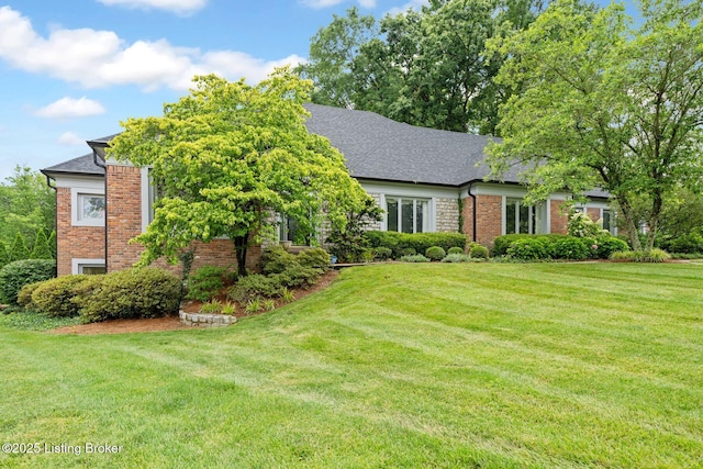 527 Woodlake Dr, Louisville, KY 40245 - view of property hidden behind natural elements featuring a front yard, brick siding, and roof with shingles