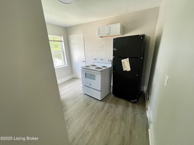4143 Hillview Ave, Louisville, KY 40216 - kitchen featuring white range with electric stovetop, freestanding refrigerator, light wood-type flooring, white cabinetry, and baseboards