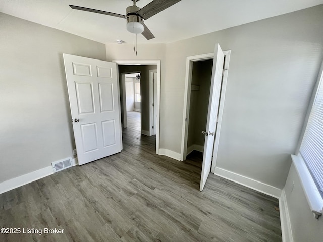4143 Hillview Ave, Louisville, KY 40216 - unfurnished bedroom featuring baseboards, wood finished floors, ceiling fan, and multiple windows