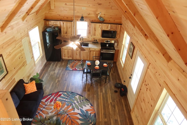 255 Little Cabin Ln, Falls Of Rough, KY 40119 - kitchen with black appliances, wood walls, dark wood-style floors, light brown cabinetry, and light countertops