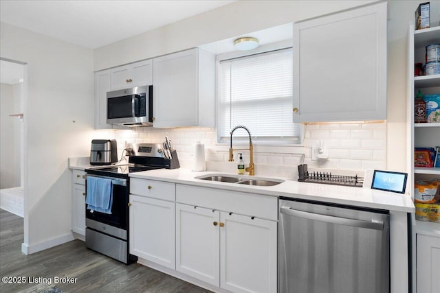 812 Castlewood Dr, New Albany, IN 47150 - kitchen with stainless steel appliances, a sink, dark wood-style floors, decorative backsplash, and light countertops