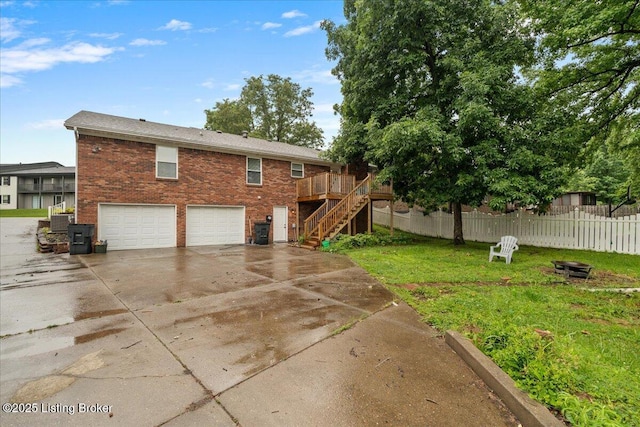 812 Castlewood Dr, New Albany, IN 47150 - back of property with stairs, concrete driveway, a garage, brick siding, and a wooden deck