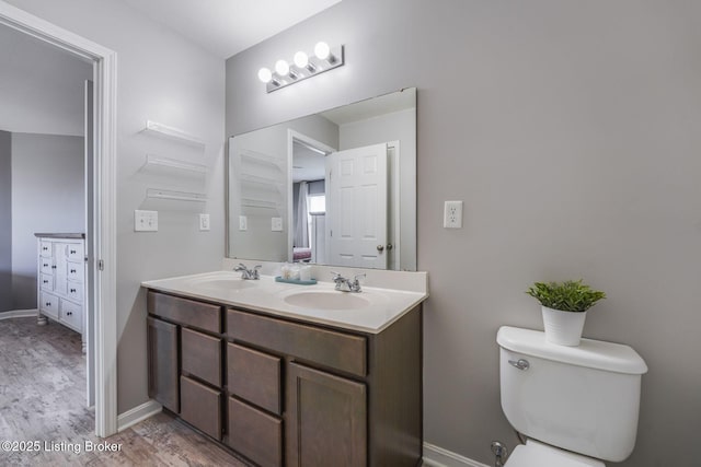108 Ruby Farm Dr, Mt Washington, KY 40047 - bathroom featuring wood finished floors, double vanity, toilet, and baseboards