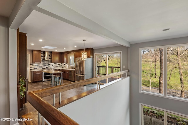 1140 Rostrevor Cir, Louisville, KY 40205 - kitchen with appliances with stainless steel finishes, recessed lighting, backsplash, wall chimney range hood, and light countertops