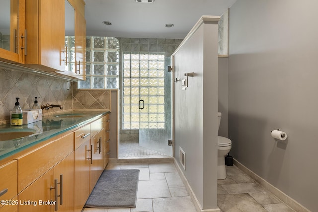 1140 Rostrevor Cir, Louisville, KY 40205 - bathroom with toilet, a stall shower, backsplash, double vanity, and baseboards