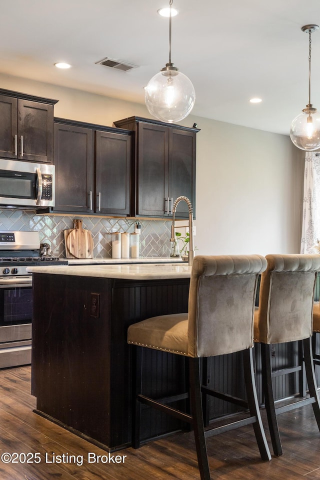 6803 Park Vista Way, Louisville, KY 40229 - kitchen featuring appliances with stainless steel finishes, dark brown cabinetry, decorative backsplash, light countertops, and recessed lighting