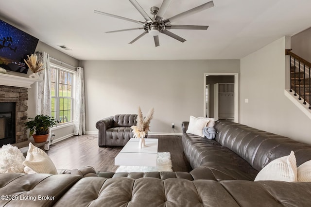6803 Park Vista Way, Louisville, KY 40229 - living room featuring stairway, a ceiling fan, baseboards, wood finished floors, and a stone fireplace