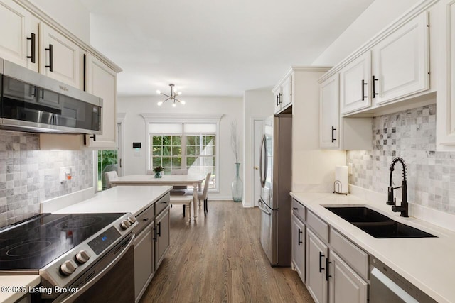 4705 Holly Forest Ct, Louisville, KY 40245 - kitchen featuring stainless steel appliances, a sink, tasteful backsplash, dark wood-type flooring, and light countertops