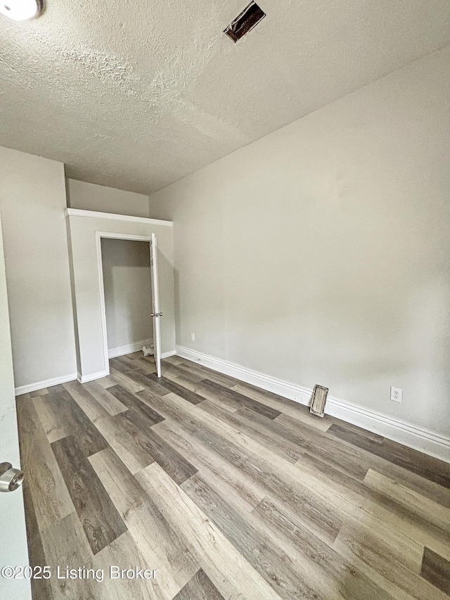 1724 Garland Ave, Louisville, KY 40210 - unfurnished bedroom featuring dark wood-style flooring, a textured ceiling, and baseboards