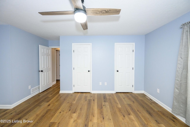 198 Cecilia Smiths Mill Rd, Cecilia, KY 42724 - unfurnished bedroom with wood finished floors, baseboards, two closets, and ceiling fan