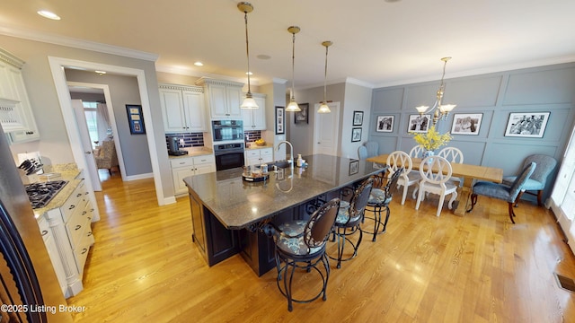 103 Morgan Ct, Bardstown, KY 40004 - kitchen featuring light wood-type flooring, a sink, a kitchen breakfast bar, an island with sink, and hanging light fixtures