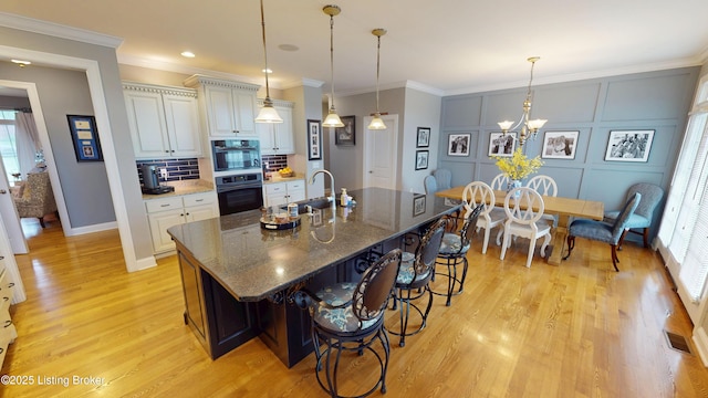 103 Morgan Ct, Bardstown, KY 40004 - kitchen with a sink, a kitchen bar, light wood-style floors, plenty of natural light, and ornamental molding