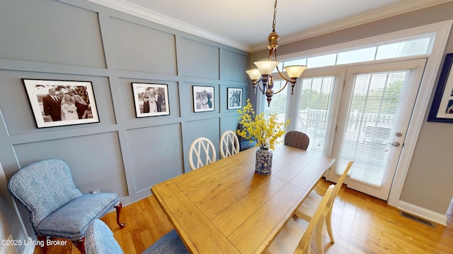 103 Morgan Ct, Bardstown, KY 40004 - dining area with a chandelier, crown molding, a decorative wall, and light wood-type flooring