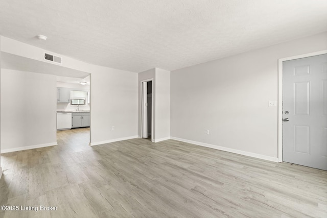 623 Westport Rd, Elizabethtown, KY 42701 - unfurnished living room with light wood-style flooring, baseboards, and a textured ceiling