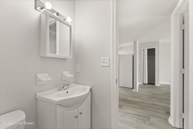 623 Westport Rd, Elizabethtown, KY 42701 - half bath with vanity, wood finished floors, toilet, and baseboards