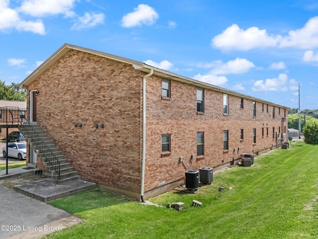 623 Westport Rd, Elizabethtown, KY 42701 - view of property exterior with central AC, a yard, stairs, and brick siding