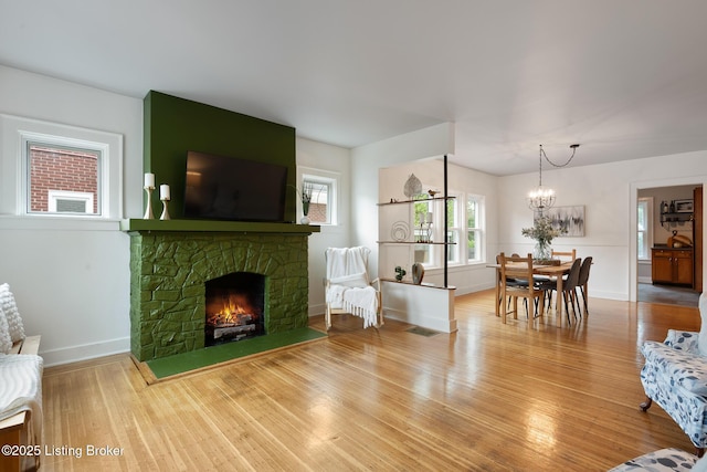 857 Melford Ave, Louisville, KY 40217 - living room featuring wood finished floors, a chandelier, baseboards, and a fireplace