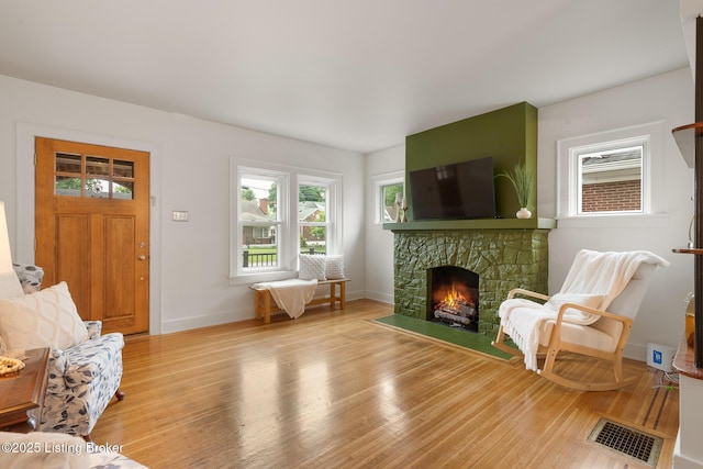857 Melford Ave, Louisville, KY 40217 - living area with plenty of natural light, a stone fireplace, light wood-style flooring, and baseboards
