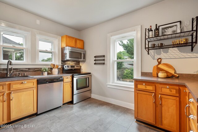 857 Melford Ave, Louisville, KY 40217 - kitchen with appliances with stainless steel finishes, a sink, baseboards, and tasteful backsplash