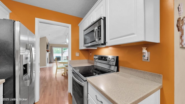 208 Forest Park Rd, Louisville, KY 40223 - kitchen featuring appliances with stainless steel finishes, light wood finished floors, white cabinetry, light countertops, and ceiling fan