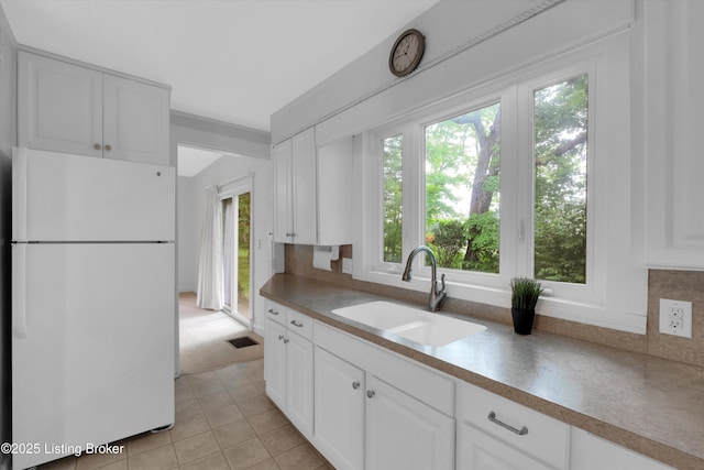 5212 Mary Clayton Ln, Crestwood, KY 40014 - kitchen featuring freestanding refrigerator, white cabinetry, light tile patterned floors, backsplash, and light countertops