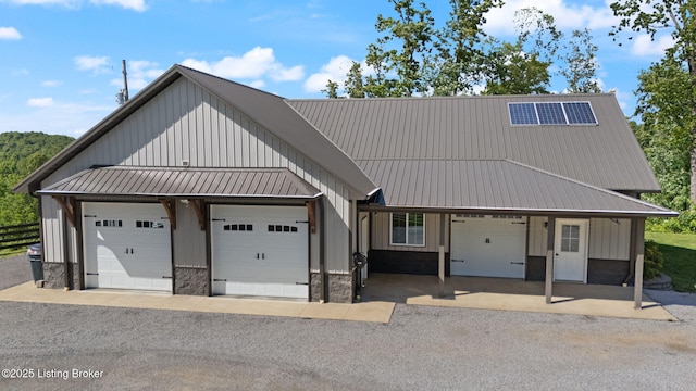 684 Cheslon Rd, Munfordville, KY 42765 - view of front of home featuring board and batten siding, metal roof, a standing seam roof, an attached garage, and stone siding