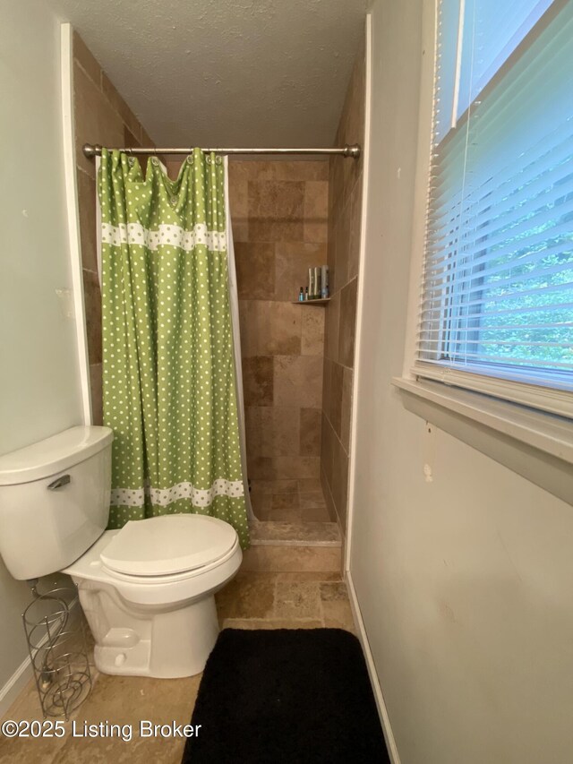 682 Hornback Mill Ln, Leitchfield, KY 42754 - bathroom featuring toilet, a tile shower, and baseboards