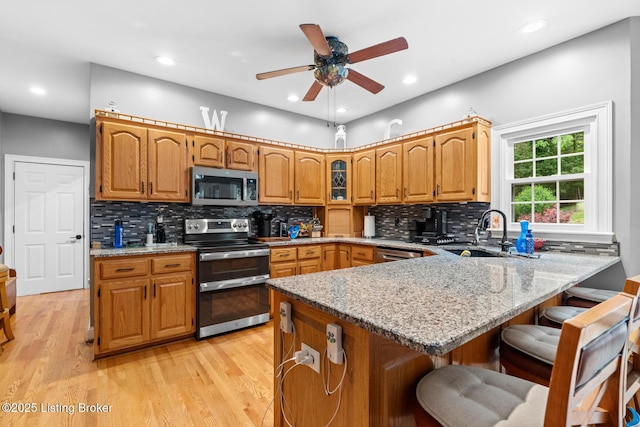4011 Serendipity Ln, Louisville, KY 40272 - kitchen featuring stainless steel appliances, a sink, a kitchen bar, a peninsula, and light stone counters