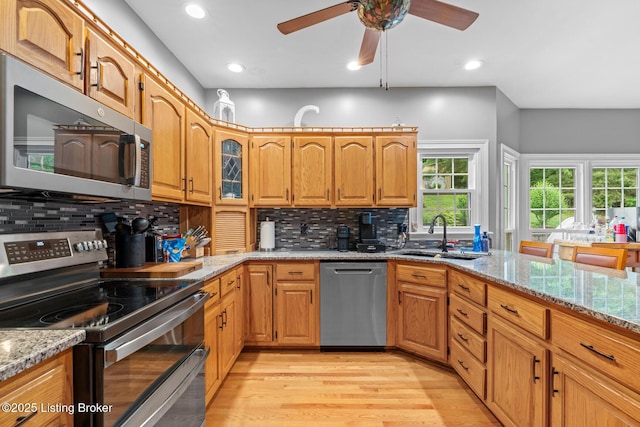 4011 Serendipity Ln, Louisville, KY 40272 - kitchen featuring stainless steel appliances, a sink, light wood finished floors, light stone countertops, and backsplash