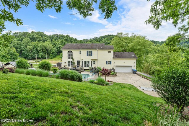 4011 Serendipity Ln, Louisville, KY 40272 - back of property featuring a yard, an attached garage, driveway, and a wooded view