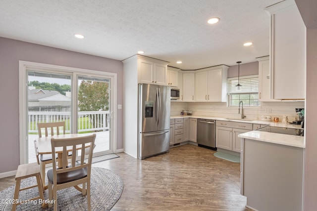 5704 Bartview Ct, Louisville, KY 40229 - kitchen with appliances with stainless steel finishes, a sink, decorative backsplash, wood finished floors, and recessed lighting