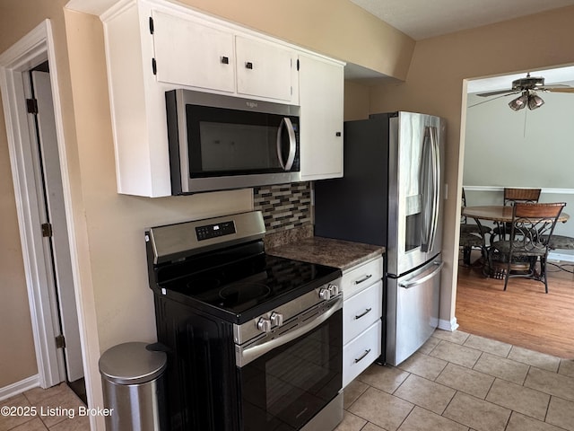 7005 Shareith Dr, Louisville, KY 40228 - kitchen featuring stainless steel appliances, light tile patterned floors, a ceiling fan, white cabinetry, and tasteful backsplash
