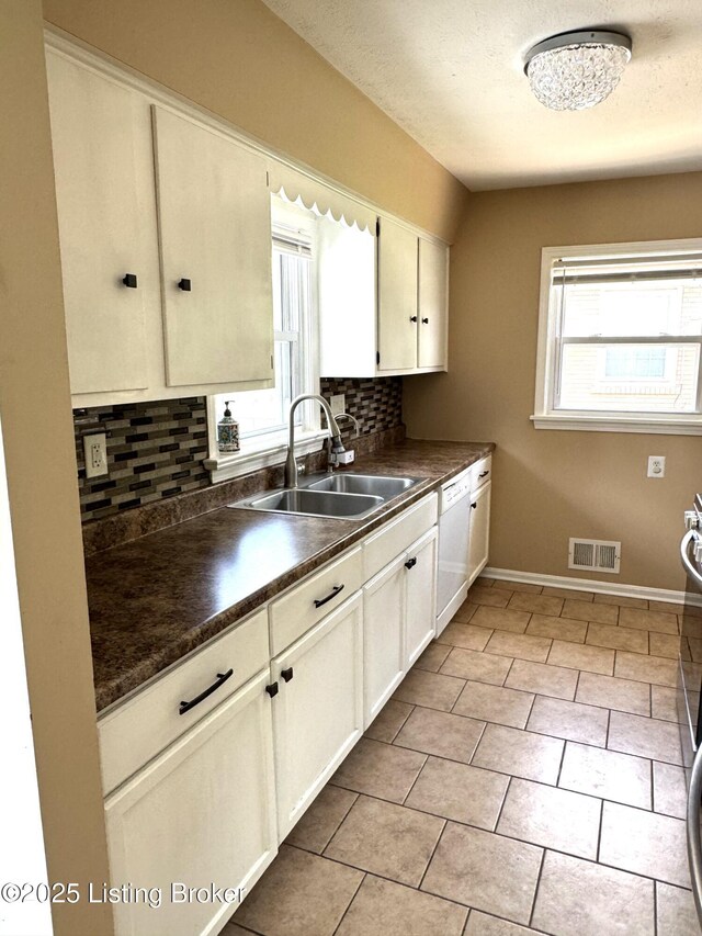 7005 Shareith Dr, Louisville, KY 40228 - kitchen featuring a sink, white dishwasher, tasteful backsplash, and dark countertops
