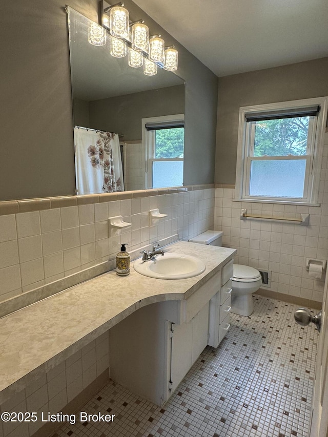 7005 Shareith Dr, Louisville, KY 40228 - full bath with tile patterned floors, vanity, tile walls, toilet, and wainscoting
