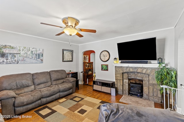 715 Woodland Ave, Frankfort, KY 40601 - living area with arched walkways, a wood stove, a ceiling fan, wood finished floors, and crown molding