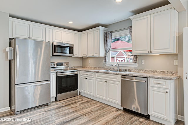 1507 Glenrock Rd, Louisville, KY 40216 - kitchen with stainless steel appliances, a sink, white cabinets, light wood finished floors, and recessed lighting