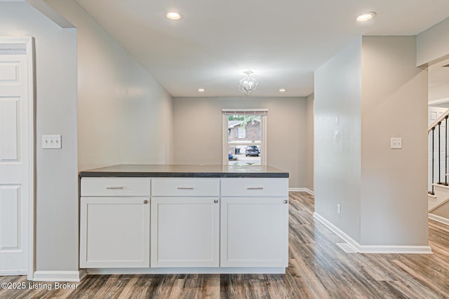 1507 Glenrock Rd, Louisville, KY 40216 - kitchen with dark countertops, white cabinets, baseboards, wood finished floors, and recessed lighting