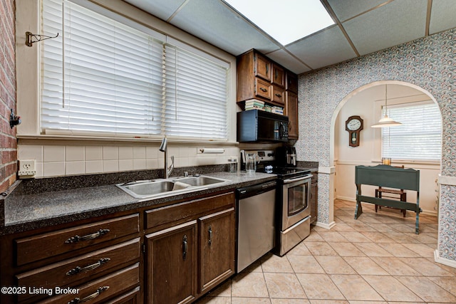 916 Audubon Pkwy, Audubon Park, KY 40213 - kitchen with wallpapered walls, a sink, appliances with stainless steel finishes, dark countertops, and dark brown cabinetry