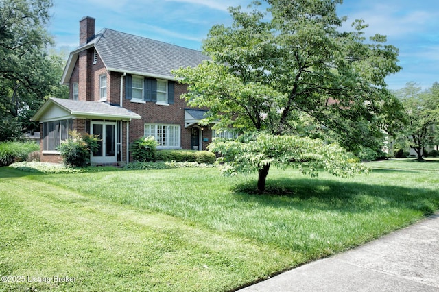 916 Audubon Pkwy, Audubon Park, KY 40213 - view of front of property featuring brick siding, a chimney, a sunroom, and a front yard