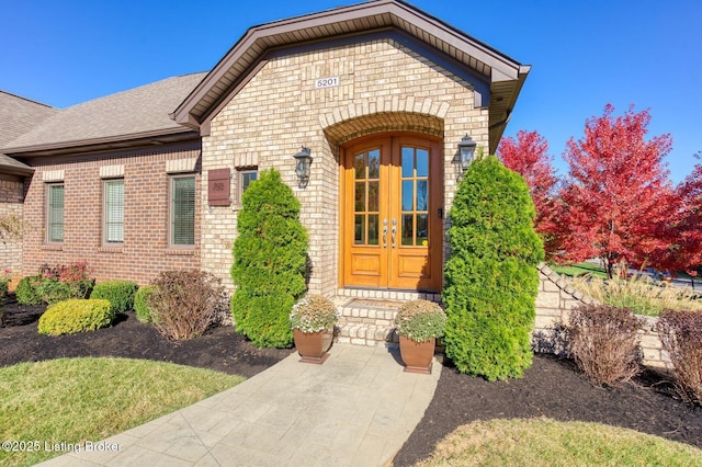 5201 Spring Mist Ct, Prospect, KY 40059 - view of exterior entry with french doors, brick siding, stone siding, and a shingled roof