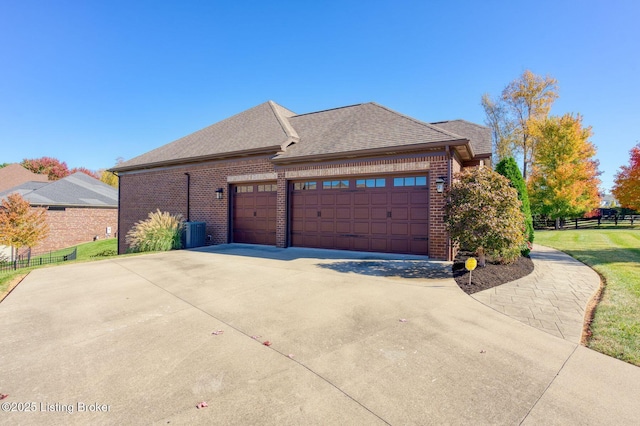 5201 Spring Mist Ct, Prospect, KY 40059 - view of side of property featuring brick siding, a garage, central air condition unit, roof with shingles, and driveway