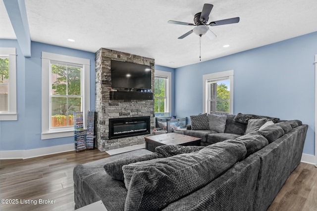 3106 Ramser Ave, Louisville, KY 40216 - living area with plenty of natural light, a fireplace, wood finished floors, a ceiling fan, and a textured ceiling